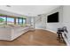 Bright living room with a sectional sofa, large windows, and mounted television for ultimate relaxation at 12795 Fisherville Way, Riverview, FL 33579