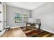 Well-lit office space featuring wood floors, a desk, and two windows overlooking the front yard at 12795 Fisherville Way, Riverview, FL 33579