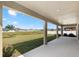 Covered patio providing a serene view of the lush backyard and neighborhood with bright blue skies above at 12795 Fisherville Way, Riverview, FL 33579