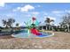 Community pool area featuring a splash zone with colorful slides and seating under a bright, sunny sky at 12795 Fisherville Way, Riverview, FL 33579