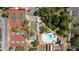 Aerial view showcases community amenities: tennis, basketball, pickleball courts, and a sparkling pool at 12904 Teakwood Ln, Hudson, FL 34667
