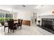 Bright dining room next to brick fireplace and a view to the outdoors through a large window at 12904 Teakwood Ln, Hudson, FL 34667