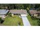 Aerial view of a single-story home with a well-kept lawn, mature trees, and a long driveway at 12904 Teakwood Ln, Hudson, FL 34667
