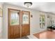 Inviting foyer features a decorative glass front door, tiled flooring, and natural light from a window at 12904 Teakwood Ln, Hudson, FL 34667