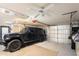 This is a spacious garage with a ceiling fan and storage, large enough to accommodate a car at 12904 Teakwood Ln, Hudson, FL 34667