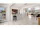 Hallway view to the kitchen showcases a breakfast bar, stainless steel appliances, and tile flooring at 12904 Teakwood Ln, Hudson, FL 34667