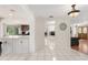 Bright hallway connects living spaces, showcasing tile floors, open floor plan, and access to kitchen at 12904 Teakwood Ln, Hudson, FL 34667