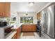 Updated kitchen with modern stainless steel appliances, light countertops, and a bright window overlooking the yard at 12904 Teakwood Ln, Hudson, FL 34667