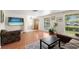 Inviting living room with hardwood floors, large windows, and comfortable seating arrangements at 12904 Teakwood Ln, Hudson, FL 34667