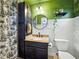 Bathroom with dark vanity, patterned shower curtain, and decorative round mirror at 14350 11Th St, Dade City, FL 33523