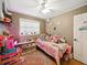 Cozy bedroom offering a ceiling fan, a window with blinds and a playful array of toys at 14350 11Th St, Dade City, FL 33523