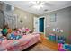 Vibrant bedroom showcasing a ceiling fan, wood paneling, and ample toys on the bed at 14350 11Th St, Dade City, FL 33523
