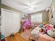Charming bedroom featuring a ceiling fan, wood paneling and filled with an assortment of toys at 14350 11Th St, Dade City, FL 33523