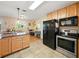 Open kitchen design with stainless steel appliances, black refrigerator, and adjacent breakfast nook at 14350 11Th St, Dade City, FL 33523