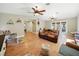 Bright living room with wood floors, ceiling fans, a brown leather sofa, and access to the backyard at 14350 11Th St, Dade City, FL 33523