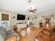 Open-concept living room with wood floors, ceiling fans, comfortable seating, and abundant natural light at 14350 11Th St, Dade City, FL 33523