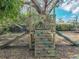 Backyard playground features a wooden play structure with a slide, climbing wall, and steering wheel at 14350 11Th St, Dade City, FL 33523