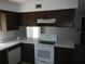 Efficient kitchen featuring wood cabinets, white appliances, and a window offering ample natural light at 14614 Lake Magdalene Cir, Tampa, FL 33613
