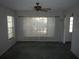 A sunlit living room with large windows, neutral paint, and a ceiling fan at 14614 Lake Magdalene Cir, Tampa, FL 33613