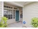 Inviting home entryway with a teal door, sidelight windows, and a security system for added peace of mind at 1640 Lullwater Ln, Lutz, FL 33549