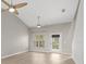 Bright living room featuring vaulted ceilings, modern ceiling fans, wood-look floors, and a sliding glass door at 1640 Lullwater Ln, Lutz, FL 33549