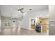 Open-concept living room with wood floors, high ceilings, ceiling fans, leading to a well-appointed kitchen at 1640 Lullwater Ln, Lutz, FL 33549