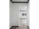 Hallway leading into a bright room with wood-look floors, white walls, and gray trim at 1820 Mississippi Ave Ne, St Petersburg, FL 33703