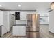 Bright kitchen featuring stainless steel refrigerator, white cabinets, and modern wine rack at 1820 Mississippi Ave Ne, St Petersburg, FL 33703
