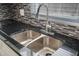 Stainless steel sink with a modern faucet set against a gray mosaic tile backsplash and granite countertops at 1820 Mississippi Ave Ne, St Petersburg, FL 33703