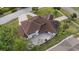 An aerial view of a home showing a large brick patio with outdoor furniture and lush green landscaping at 1915 Belleair Rd, Clearwater, FL 33764