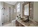 Bathroom showing glass shower and vanity with a bowl sink and decorative mirror at 1915 Belleair Rd, Clearwater, FL 33764
