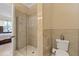Well-lit bathroom featuring a glass shower and neutral tile at 1915 Belleair Rd, Clearwater, FL 33764
