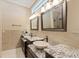 Bathroom features dual sinks with granite countertops, decorative mirrors, and modern lighting at 1915 Belleair Rd, Clearwater, FL 33764