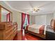 Bedroom with hardwood floors, dresser, double closets, and sliding door to balcony at 1915 Belleair Rd, Clearwater, FL 33764