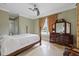 Bedroom features a four-poster bed, a dresser with a mirror, and a ceiling fan at 1915 Belleair Rd, Clearwater, FL 33764