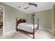 A serene bedroom showcasing a four-poster bed, ceiling fan and neutral color palette at 1915 Belleair Rd, Clearwater, FL 33764