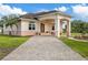 Charming home featuring a brick-paved driveway, arched entryway, and manicured lawn at 1915 Belleair Rd, Clearwater, FL 33764