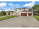 Elegant two-story home featuring a three-car garage and a spacious brick driveway at 1915 Belleair Rd, Clearwater, FL 33764