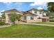 Stately home showcasing a well-manicured lawn, mature trees, and a side-entry three car garage at 1915 Belleair Rd, Clearwater, FL 33764