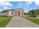 Beautiful home with a covered entryway, manicured lawn, and a brick driveway leading to the property at 1915 Belleair Rd, Clearwater, FL 33764