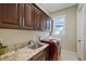 Functional laundry room features sleek cabinetry, granite counters, stainless steel sink, and modern washer/dryer at 1915 Belleair Rd, Clearwater, FL 33764