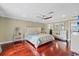 Bright main bedroom featuring a ceiling fan, wood floors, and access to the en-suite bathroom and walk-in closet at 1915 Belleair Rd, Clearwater, FL 33764