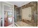 Bathroom showing tiled shower with glass door and view to bedroom with hardwood floors at 1915 Belleair Rd, Clearwater, FL 33764