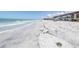 Scenic beach view with calm ocean waves and distant buildings, ideal for relaxation and coastal living at 2800 Gulf Blvd Unit # 1A, Belleair Beach, FL 33786