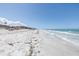 Panoramic view of the serene beach with gentle waves lapping the shore, perfect for a relaxing getaway at 2800 Gulf Blvd Unit # 1A, Belleair Beach, FL 33786