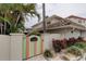 Inviting home entrance featuring a colorful gate, lush landscaping, and a charming facade at 2800 Gulf Blvd Unit # 1A, Belleair Beach, FL 33786