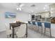 Modern kitchen with an island and barstool seating, seamlessly connected to the dining area at 2800 Gulf Blvd Unit # 1A, Belleair Beach, FL 33786