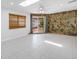 Spacious room with a stunning stone accent wall, skylight, and access to the patio at 2800 Gulf Blvd Unit # 1A, Belleair Beach, FL 33786