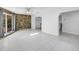 Bright and open living space featuring a stone accent wall, tile floors, and arched doorways at 2800 Gulf Blvd Unit # 1A, Belleair Beach, FL 33786