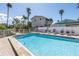 Sparkling pool is surrounded by lounge chairs and lush landscaping, perfect for relaxing and enjoying the beautiful weather at 2800 Gulf Blvd Unit # 1A, Belleair Beach, FL 33786